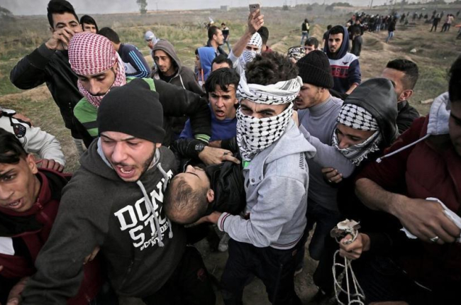 Manifestantes palestinos portan el cuerpo sin vida de Yasser Sokar, en la franja de Gaza.-EFE / MOHAMMED SABER