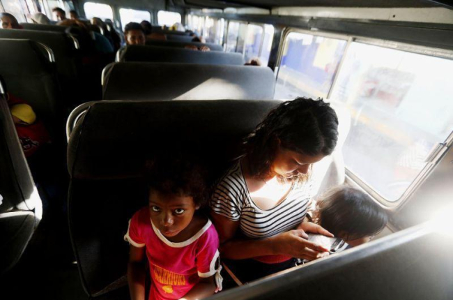 María llora junto a sus dos hijas en el autobús que las regresará voluntariamente a Honduras. María estuvo en la caravana de migrantes hondureños por más de una semana, pero el cansancio y la incertidumbre hizo que decidiera regresar.-EFE/ESTEBAN BIBA