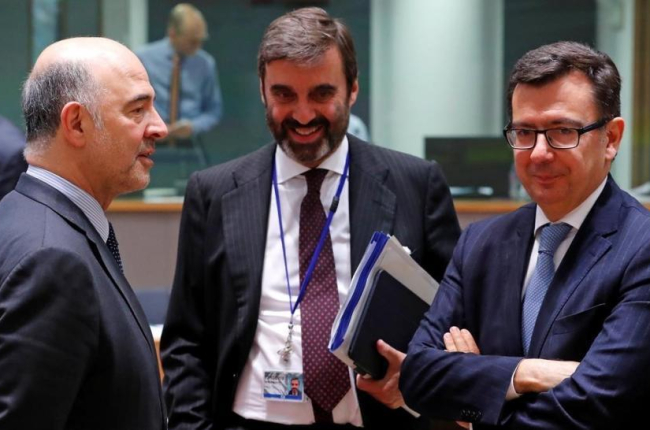 Escolano, junto al embajador español en Bélgica, Juan Pablo García Bordoy, conversa con Pierre Moscovici, comisario de Economía de la UE-YVES HERMAN (REUTERS)