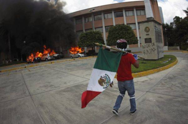 Un manifestante pasa por delante de la sede del Congreso del Estado de Guerrero.-Foto: JORGE DAN LOPEZ / REUTERS