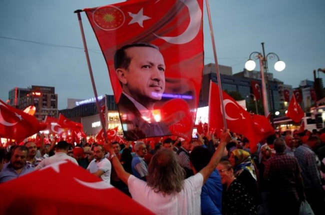 Un seguidor de Erdogan sostiene una bandera con una imagen del presidente turco, en una marcha progubernamental, en Ankara, el 20 de julio.-REUTERS / BAZ RATNER