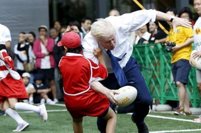 Boris Johnson colisiona contra un crío de 10 años en Tokio.-