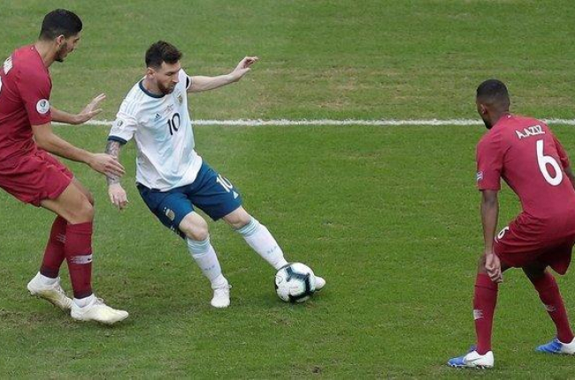 Messi controla un balón, vigilado por jugadores de Qatar.-EFE / JUAN IGNACIO RONCORONI