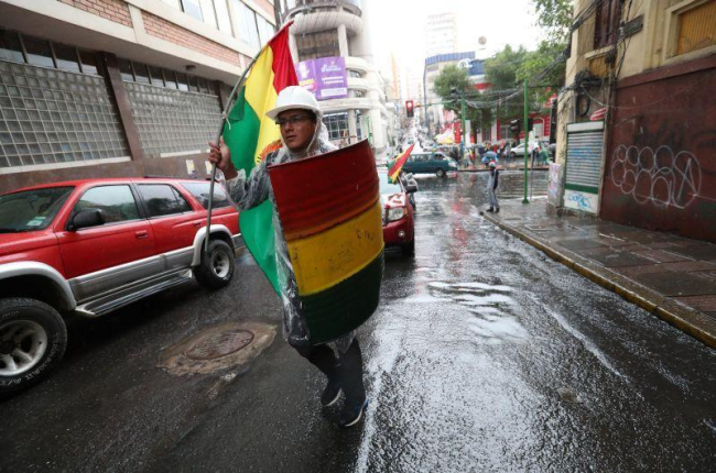 Un ciudadano contrario al expresidente Evo Morales marcha este domingo con un escudo improvisado en La Paz (Bolivia).-EFE