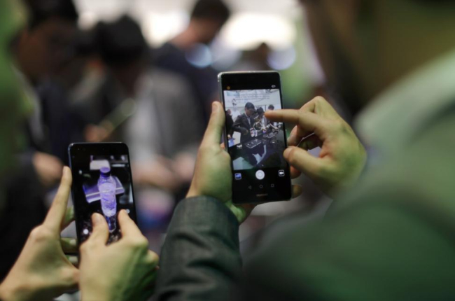 Dos personas manejan sus móviles.-REUTERS / ERIC GAILLARD