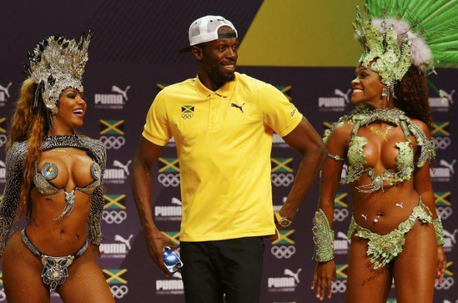 Usain Bolt baila samba con unas bailarinas, en la rueda de prensa que dio en Rio este lunes.-REUTERS / NACHO DOCE
