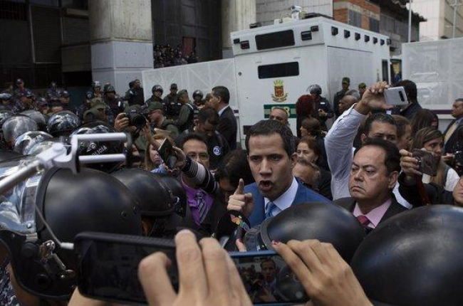 Momento en el que Juan Guaidó es impedido entrar en el edificio del Parlamento venezolano.-AP / ANDREA HERNÁNDEZ BRICE