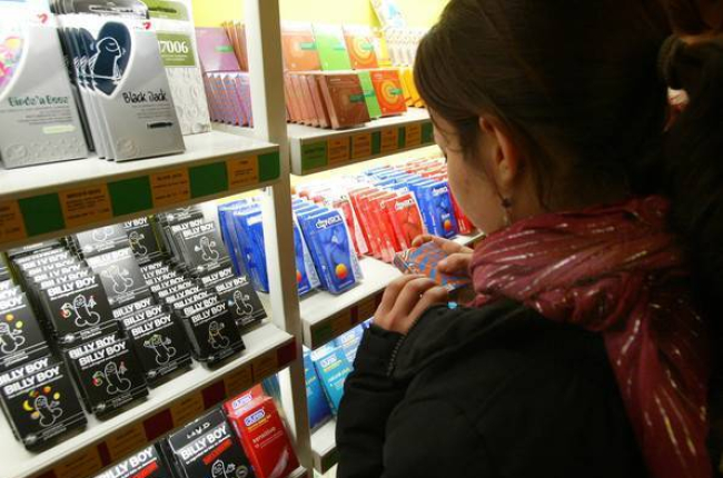 Una chica, frente a un estante repleto de preservativos en una tienda especializada de Barcelona.-Foto: SERGIO LAINZ