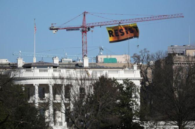 Imágenes de la bandera colgada por los ecologistas de Greenpeace en protesta contra las acciones de Trump.-CARLOS BARRIA