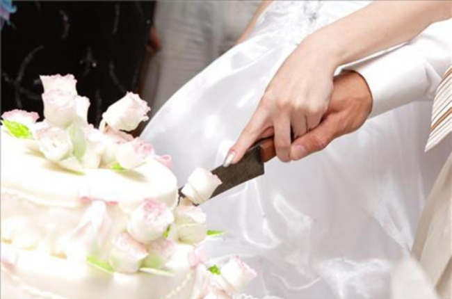 Novios cortan tarta de boda-123RF