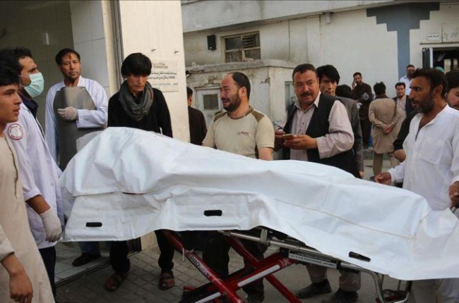 Voluntarios afganos trasladan un cuerpo en una camilla hacia el hospital.-AFP