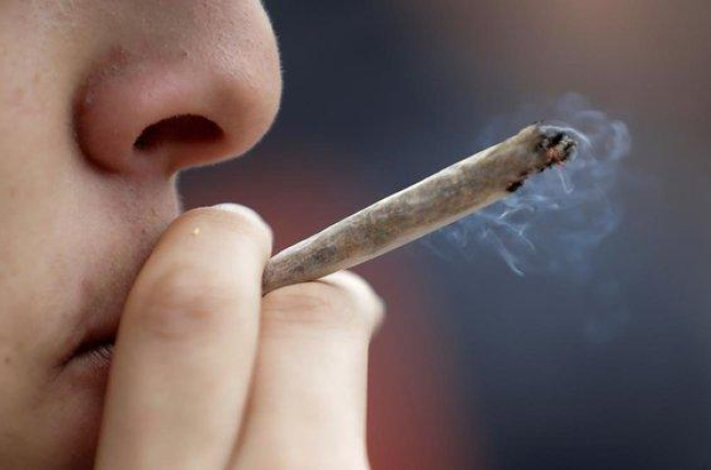 Un joven se fuma un porro durante una concentración a favor de la legalización de la marihuana.-AFP / THOMAS SAMSON