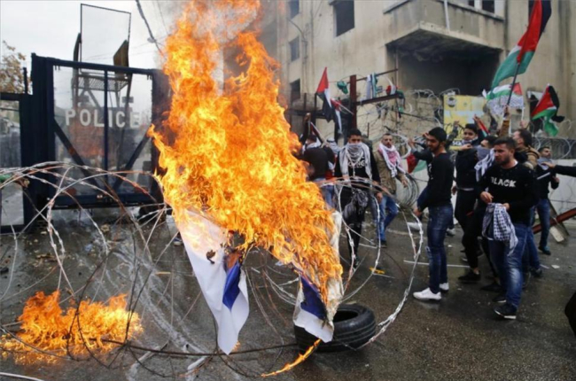 Manifestantes queman una bandera de Israel frente a la embajada de Estados Unidos en Beirut, Líbano.-AP / BILAL HUSSEIS