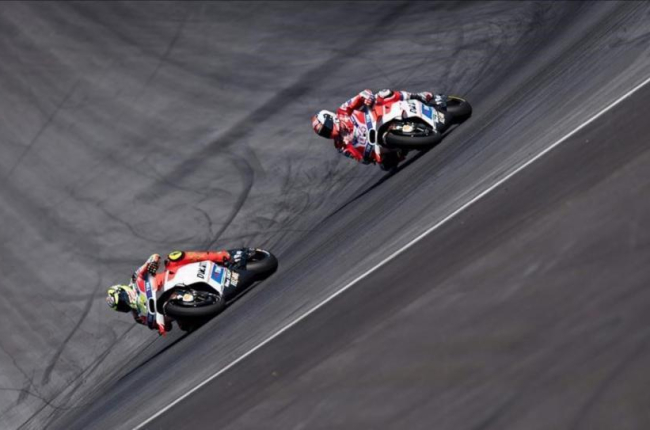Andrea Iannone (izquierda) traza una curva por delante de su compañero en Ducati Andrea Dovizioso, durante el GP de Austria de MotoGP.-AFP / JOE KLAMAR