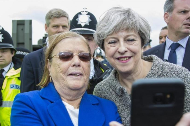 May (derecha) posa para un selfi con una asistente a una exhibición militar en Liverpool, el 24 de junio.-OWEN COOBAN
