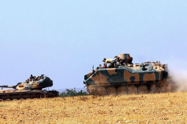 Un tanque y un vehículo blindado estacionados cerca de Karkamis, en Turquía, este martes.-AP