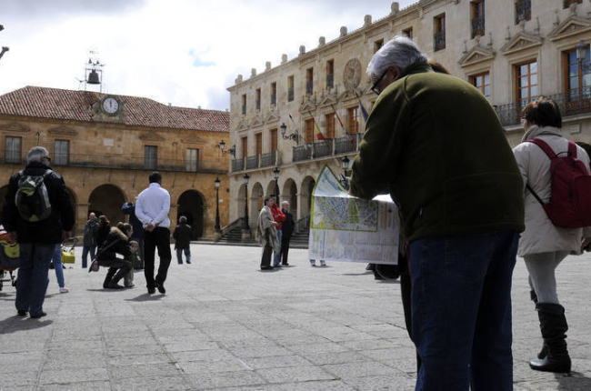 Turistas en la plaza Mayor de la capital consultando un mapa. / ÁLVARO MARTÍNEZ-
