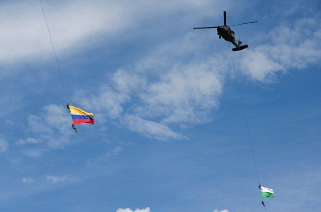 Soldados colombianos colgados de unas cuerdas en un espectáculo militar.-AFP