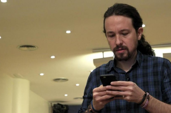 El secretario general de Podemos, Pablo Iglesias, mira su móvil antes de comparecer ante los medios, este jueves.-EFE / CHEMA MOYA