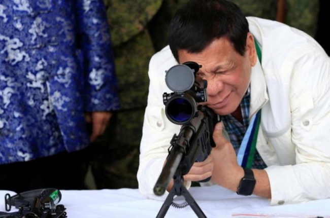 Duterte comprueba la mirilla de un rifle, hace unos días.-REUTERS / ROMEO RANOCO