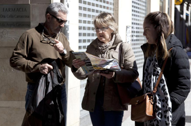 Tres personas consultan información turística en el centro de la capital.-DIEGO MAYOR