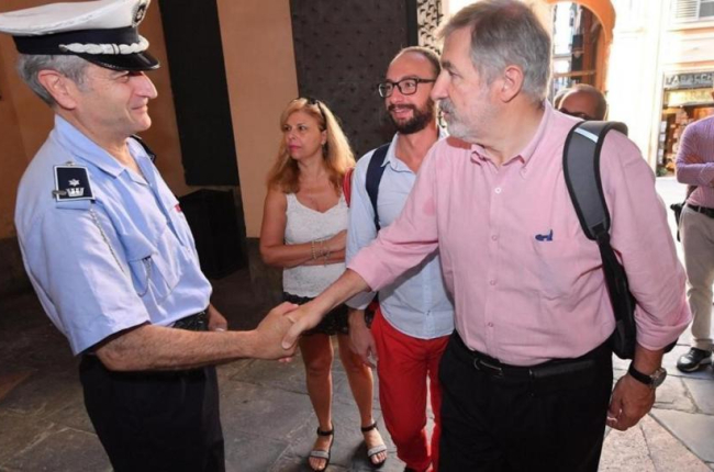 El nuevo alcalde de Génova, el conservador Marco Bucci (centro), saluda a un policía local a su llegada al Palazzo Tursi, sede de la alcaldía de Génova, el 26 de junio.-