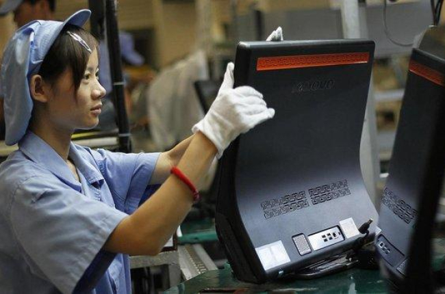 Una mujer trabaja en la línea de producción de Lenovo, en la planta que la empresa tiene en Shanghái.-EUGENE HOSHIKO (AP)