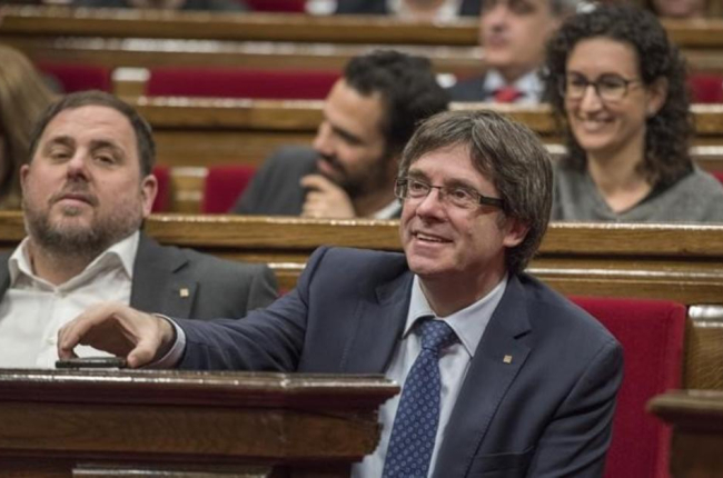 Carles Puigdemont, junto a Oriol Junqueras, en el Parlament.-FERRAN SENDRA
