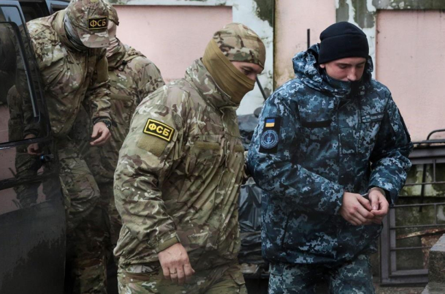 Militar ruso conduce a uno de los marineros detenidos-AFP