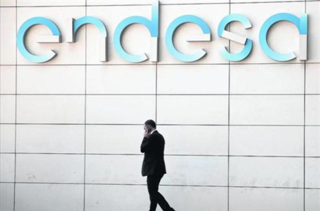Un hombre camina bajo el logo de Endesa en la sede de la empresa en Madrid.-ANDREA COMAS (REUTERS)