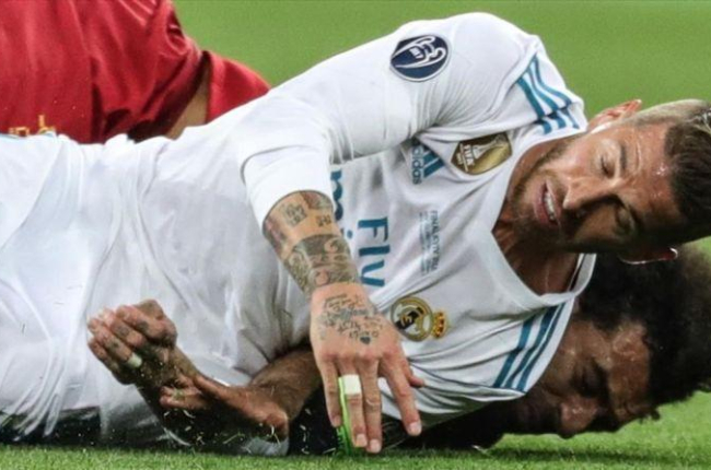 Sergio Ramos cae sobre Salah tras la disputa de un balón y le lesiona.-EFE / ARMANDO BABANI