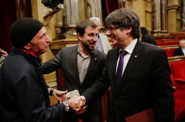El 'president' Puigdemont saluda a Lluís Llach en el Parlament.-JOAN CORTADELLAS