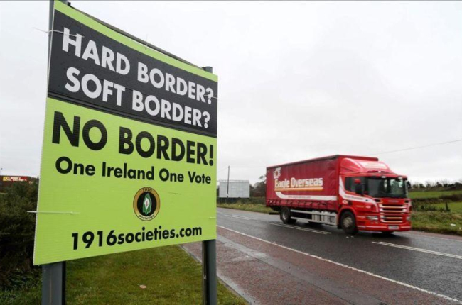 Un automóvil circula junto a un cartel que reclama que no haya frontera entre Irlanda e Irlanda del Norte.-PAUL FAITH (AFP)