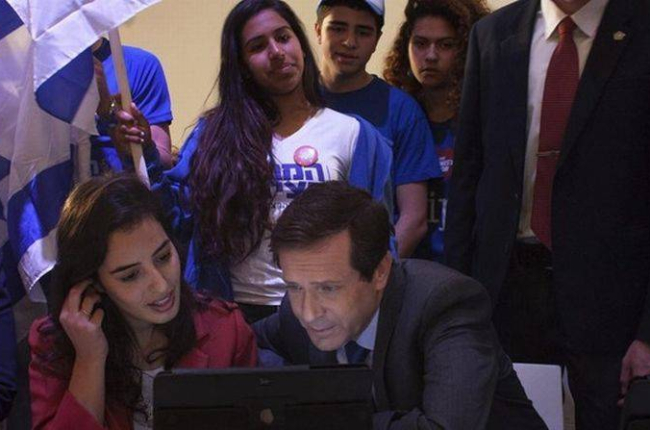 Herzog, líder de los laboristas, consulta datos en un ordenador junto a miembros del movimiento juvenil Dror, en una visita a colegios electorales en Tel-Aviv.-Foto: EFE / ANNA LOSHKIN