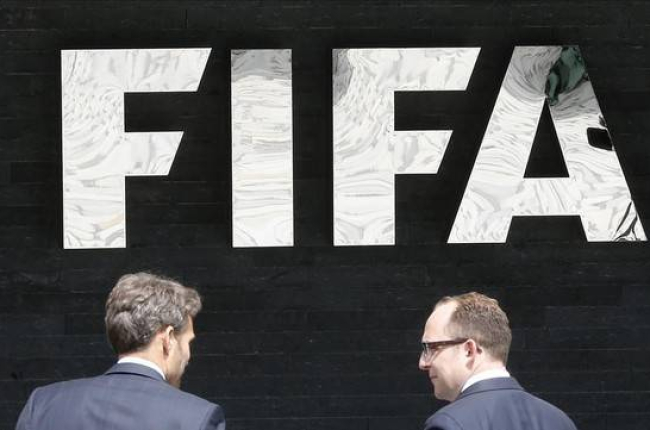 Dos hombres pasan por delante de la sede central de la FIFA en Zúrich.-Foto: AP / MICHAEL PROBST