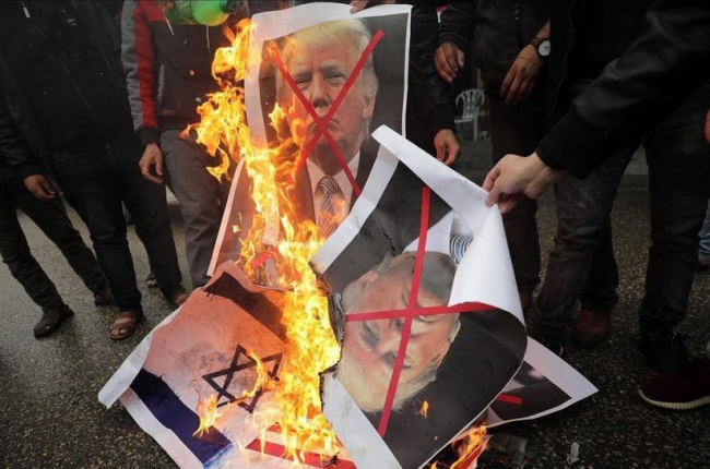 Varios palestinos, contrarios a la decisión de presidente Trump, queman su fotografía y banderas estadounidenses.-MOHAMMED SABER (EFE)