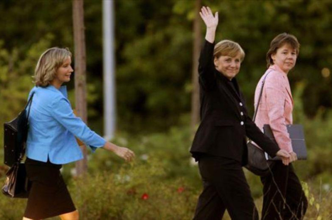 Angela Merkel, custodiada por Beate Baumann (derecha) y Eva Christiansen, a la llegada de la cancillera a un estudio de TV de Berlín.-REUTERS / ARND WIEGMANN