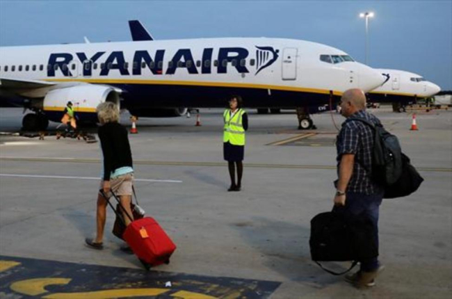 Pasajeros de Ryanair trasladando el equipaje a la aeronave.-REUTERS / KEVIN COOMBS