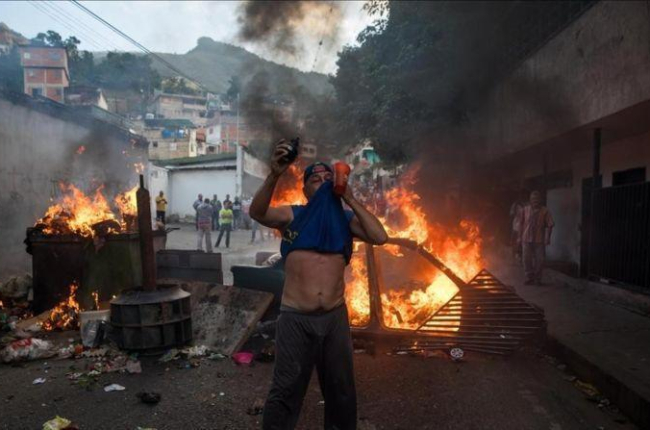 Un grupo de personas se manifiesta en una calle de Carcas (Venezuela).-MIGUEL GUTIERREZ (EFE)