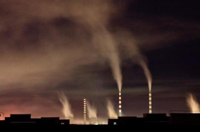 Chimeneas de una planta de energia de carbon emiten humo durante la noche en Changchun  en China-