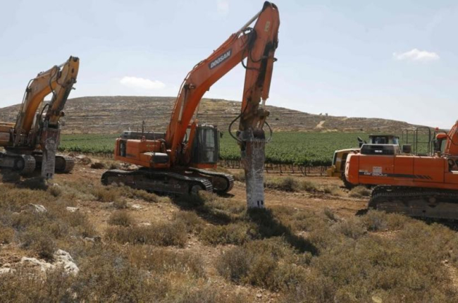Varias máquinas esperan la orden para empezar los trabajos de construcción del asentamiento de Amijai en la Cisjordania ocupada.-AFP / MENAHEM KAHANA