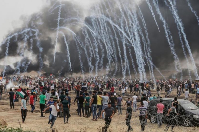 Manifestantes palestinos huyen de los gases lacrimógenos lanzados por los soldados israelís.-/ AFP / MAHMUD HAMS