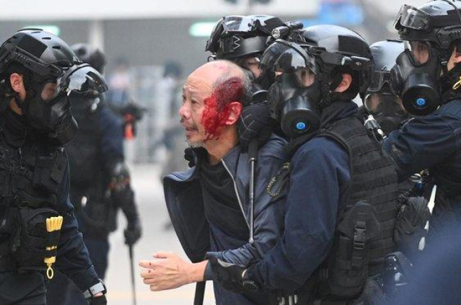 La policía se lleva a un manifestante herido en Hong Kong.-AFP / PHILIP FONG
