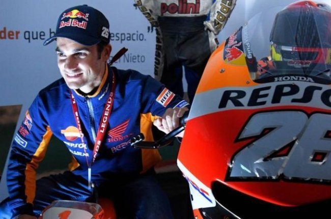 Dani Pedrosa se ha fotografiado hoy, en Valencia, el día de su adios, con una moto de juguete y su Honda RC213V nº 26.-AFP / JOSÉ JORDAN