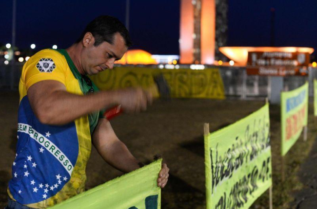 Un partidario de Rousseff clava un cartel en las afueras del senado brasileño.-ANDRESSA ANHOLETE / AP / AFP