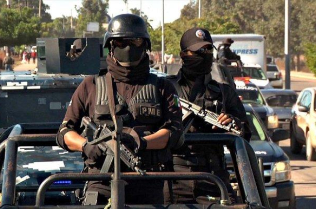 Dos agentes de la policía mexicana en un convoy de seguridad.-EL PERIÓDICO