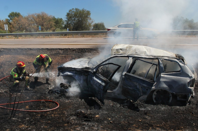 Los bomberos sofocan las llamas con el vehículo completamente calcinado. VICENTE-ICAL