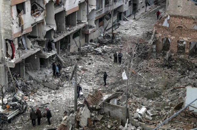 Vecinos inspeccionan los edificios en ruinas tras varios bombardeos el día anterior en Duma, feudo rebelde de Guta Oriental (Siria), el 22 de febrero.-/ EFE / MOHAMMED BADRA