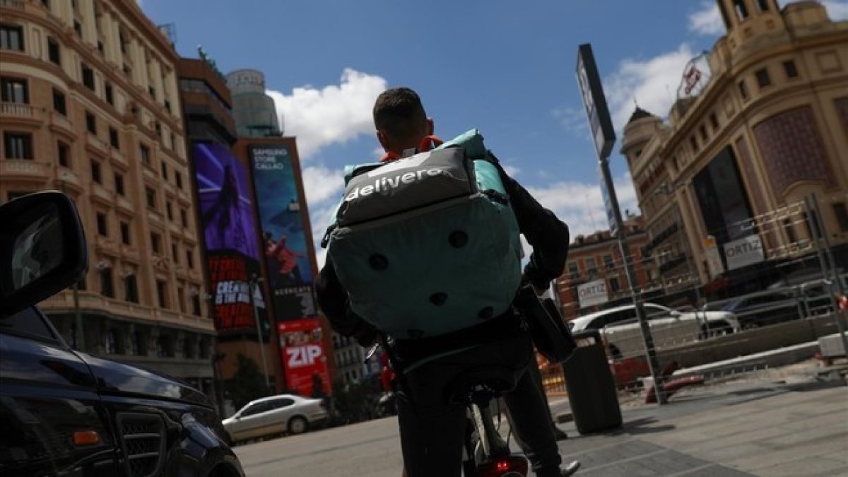 Un rider de Deliveroo realizando su reparto en su bicicleta.-SUSANA VERA (REUTERS)