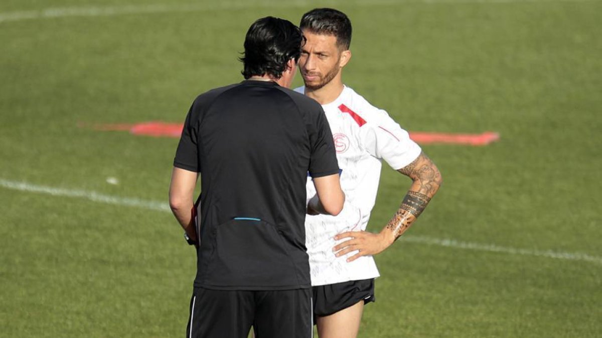 Cicinho habla con Unai Emery durante un entrenamiento del Sevilla.-ESTADIO DEPORTIVO